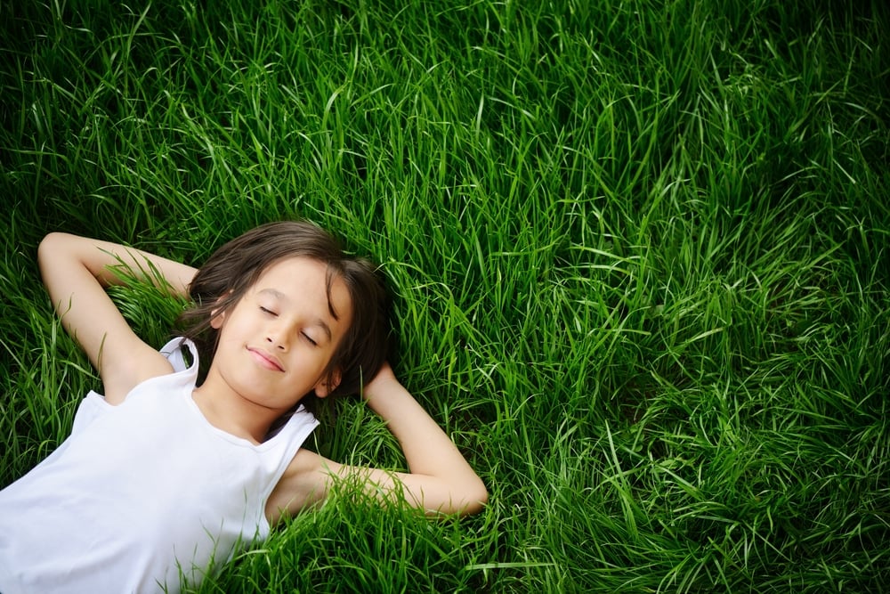 Happy child enjoying on grass field and dreaming Happy child enjoying on grass field and dreaming