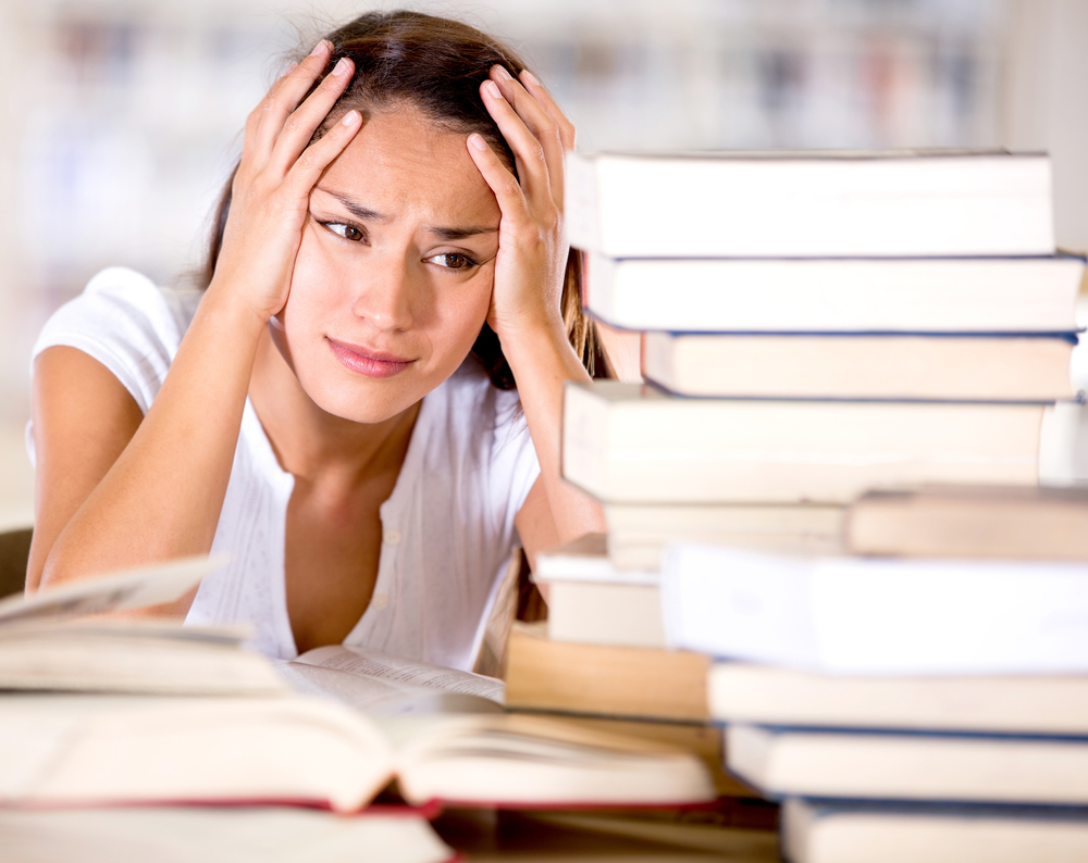 Tired female student at the library looking very frustrated